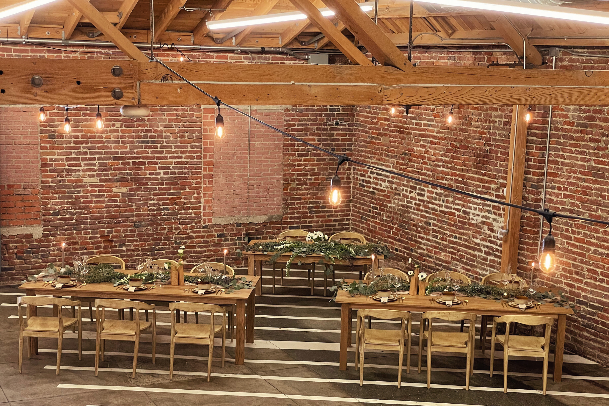 MG Studio Wedding Dinner Tables - brick walls concrete floors tablescape florals