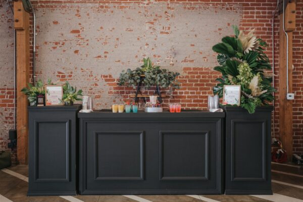 black wood bar with greenery and mixed drinks in MG Studio brick wall